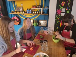 Warsztaty językowo-kulinarne usmiechniete dzieci przy stole